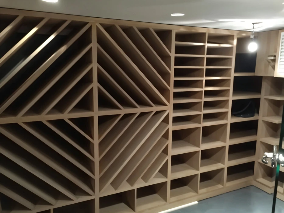Cave à vin en construction avec casiers de rangement en bois clair non finis