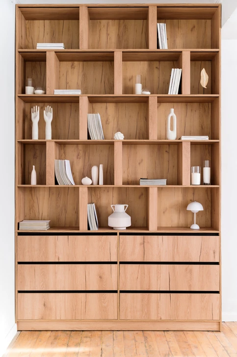 Artisan travaillant le bois avec des outils électriques dans un atelier, étincelles et fumée s'échappant de la découpe d'une planche épaisse